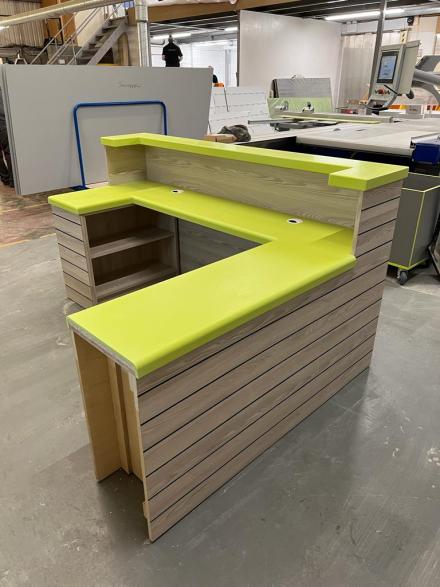 Bespoke reception desk with storage and solid surface worktop.