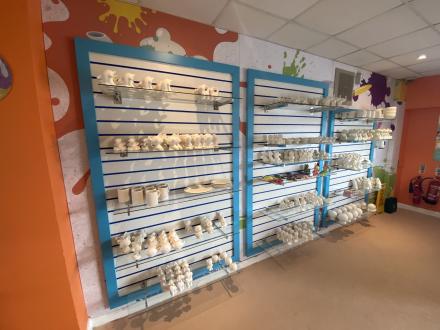 Slat walling with coloured surround and inserts, with glass shelving to display merchandise.