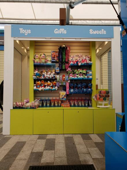 Freestanding display unit with bespoke roller shutters, slat walling and storage drawers.